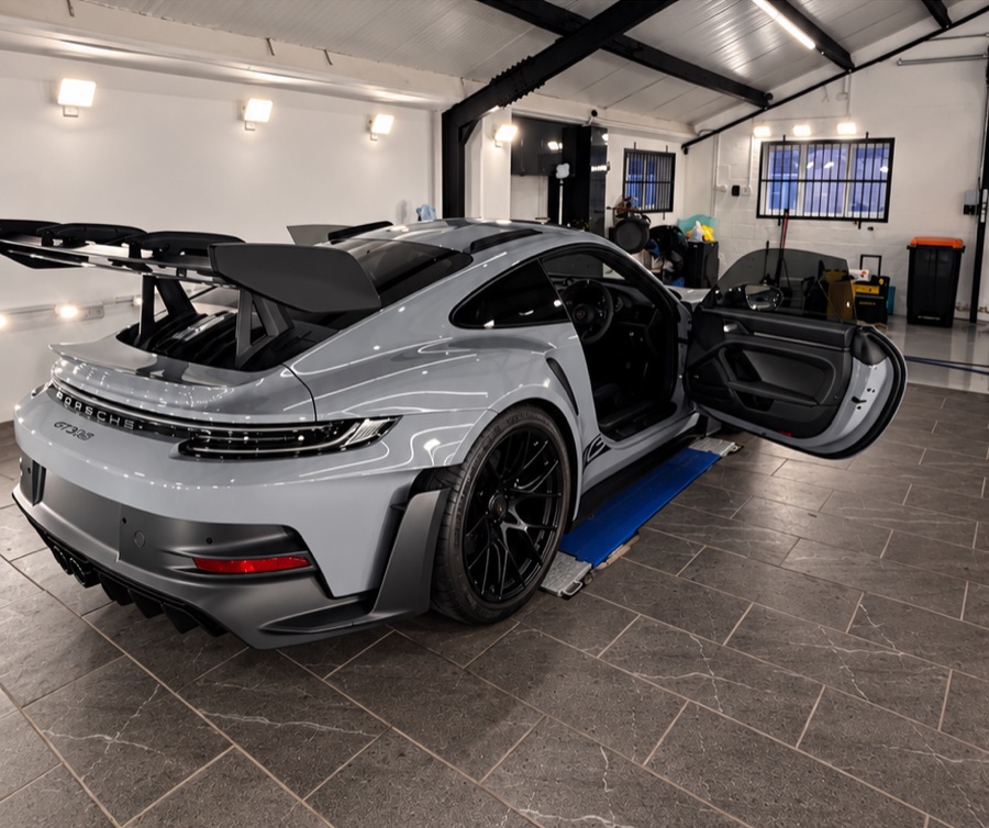 Grey Porsche 911 GT3 RS with its door open, rear three-quarter view from LuxTint’s customer work
